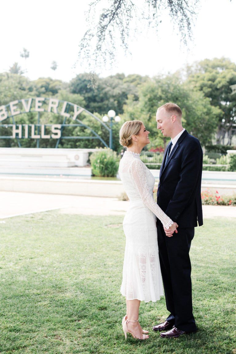bride and groom in front of beverly hills sign