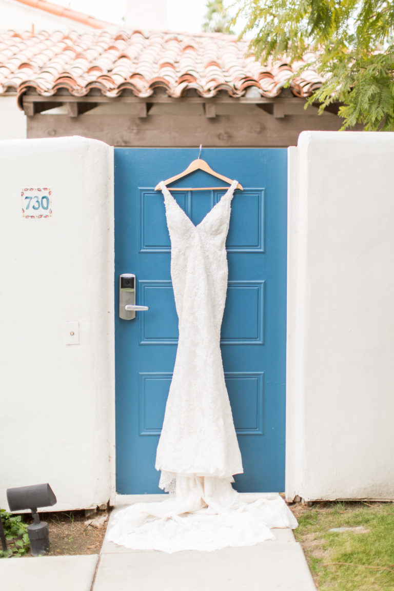 bridal gown hanging on blue door