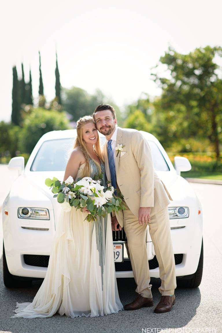 wedding couple in front of car