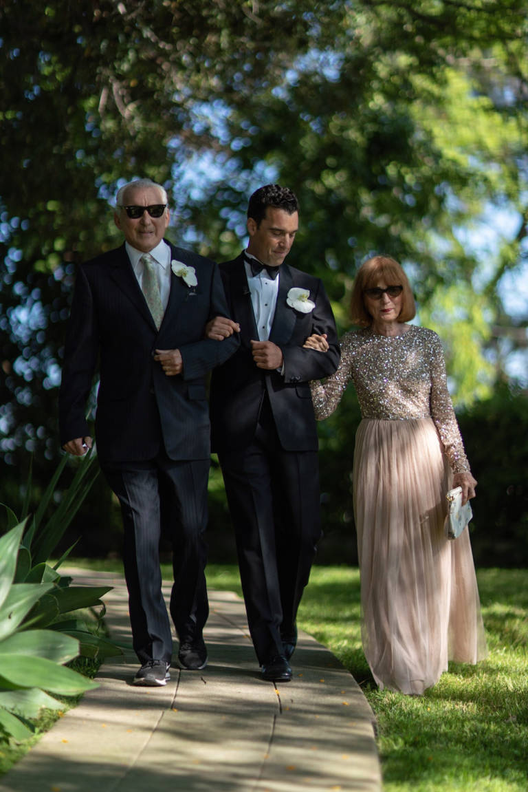 groom walking with parents