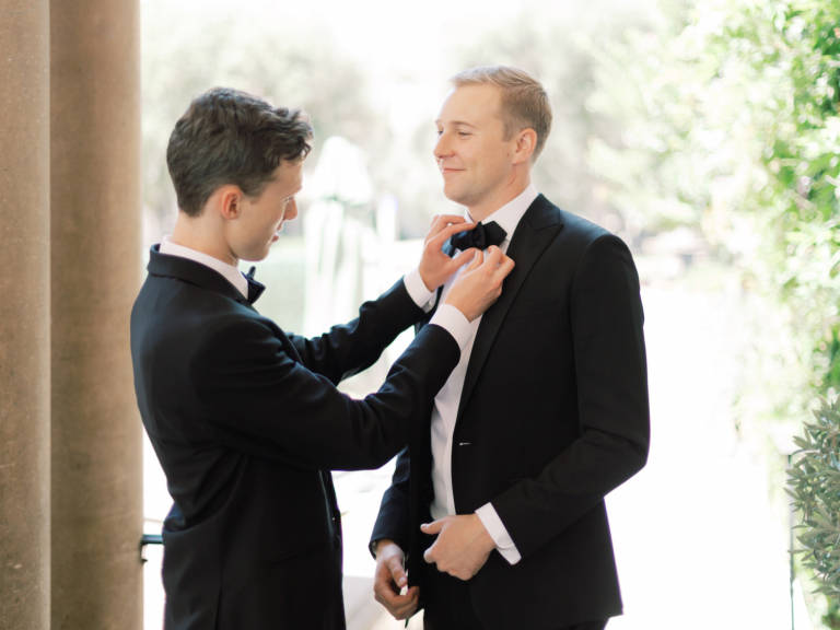 groomsmen straightens tie
